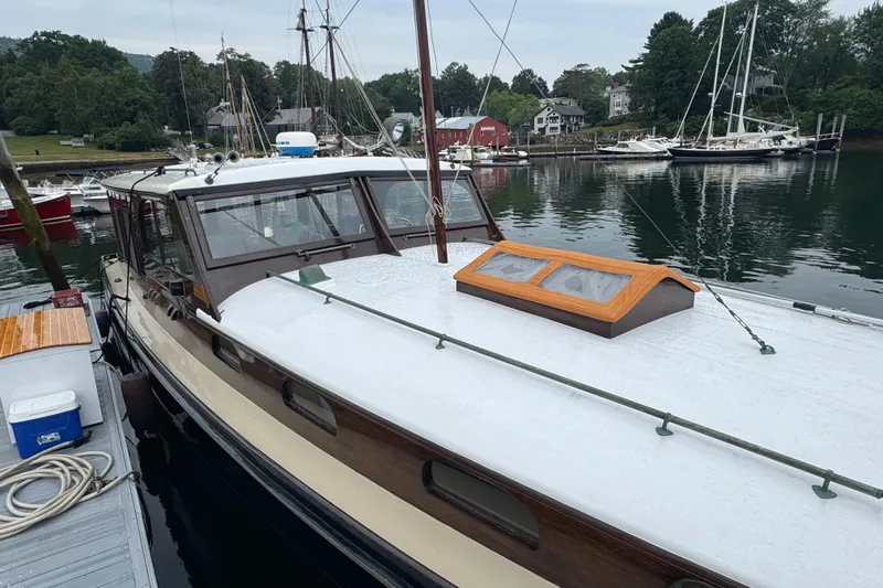 Slide: The Image of 1940 Elco Cruisette boat docked in a serene marina setting. - 5