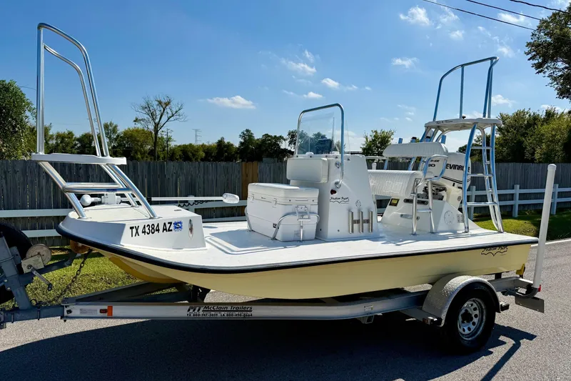 Slide: The Image of 2010 Shallow Sport 15 Classic boat on trailer, featuring elevated platforms and Evinrude motor. - 1