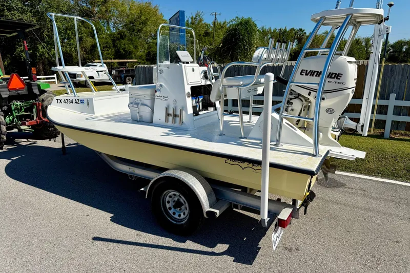 Slide: The Image of 2010 Shallow Sport 15 Classic boat on trailer with Evinrude engine, parked outdoors. - 2