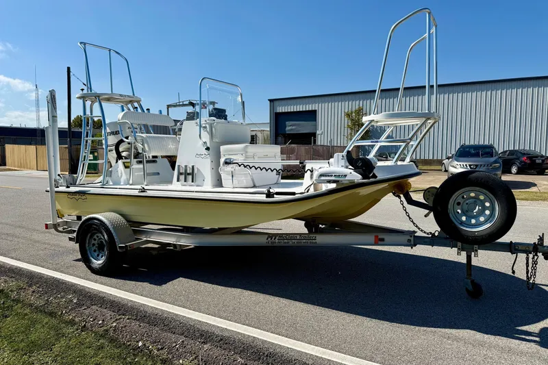 Slide: The Image of 2010 Shallow Sport 15 Classic boat on trailer, parked outdoors under clear blue sky. - 5