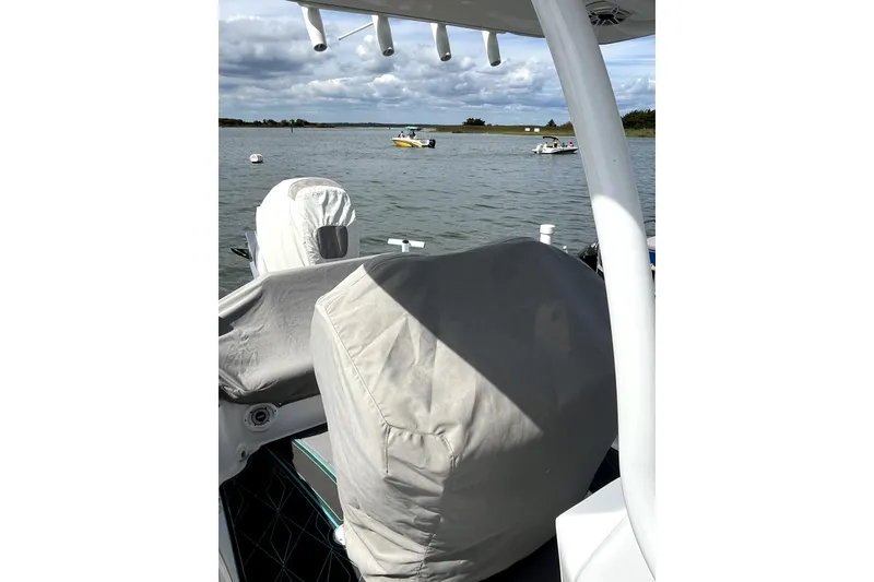 Slide: The Image of 2021 Glasstream 255 Pro-XS boat with covered seats on a calm lake. - 15