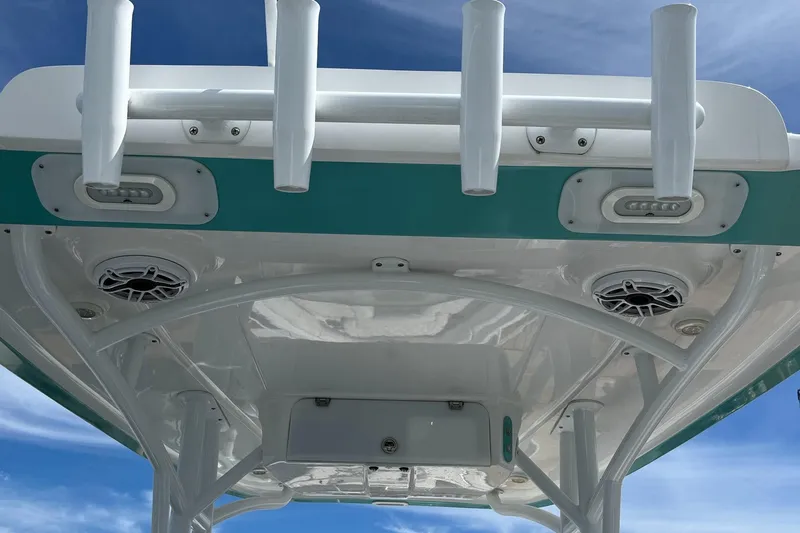 Slide: The Image of 2021 Glasstream 255 Pro-XS boat roof with rod holders and speakers under blue sky. - 21