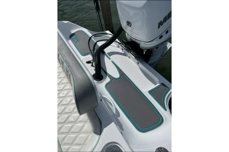 Slide: The Image of 2021 Glasstream 255 Pro-XS boat deck with cushioned seating and Mercury outboard motor. - 27