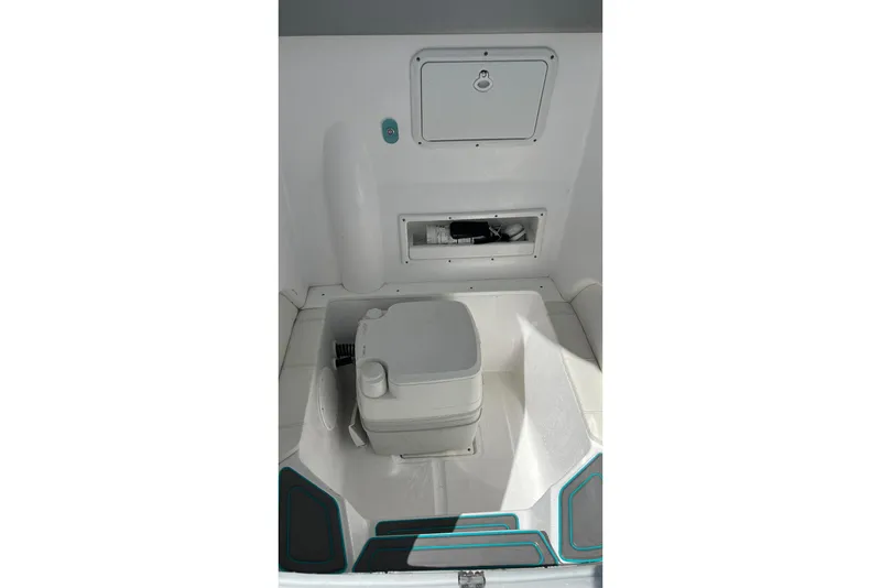 Slide: The Image of 2021 Glasstream 255 Pro-XS boat interior with storage compartments and portable toilet. - 28