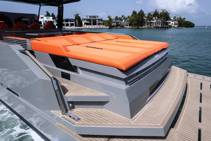 Slide: The Image of 2023 De Antonio Yachts D50 with orange sunbeds, docked near luxury waterfront homes. - 12