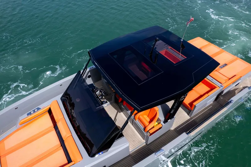 Slide: The Image of 2023 De Antonio Yachts D50 with sleek design, vibrant orange seating, cruising on open water. - 14