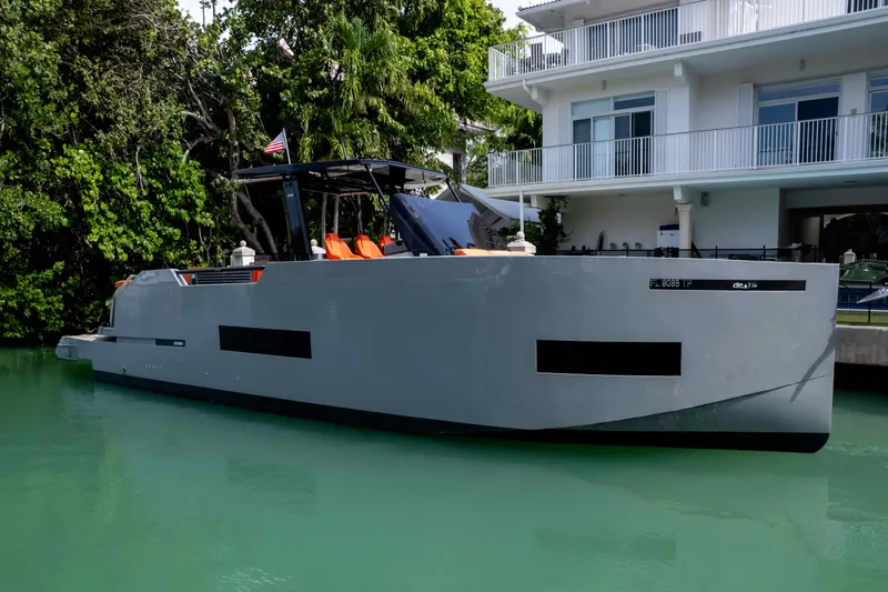 Slide: The Image of 2023 De Antonio Yachts D50 moored by a modern waterfront home. - 16