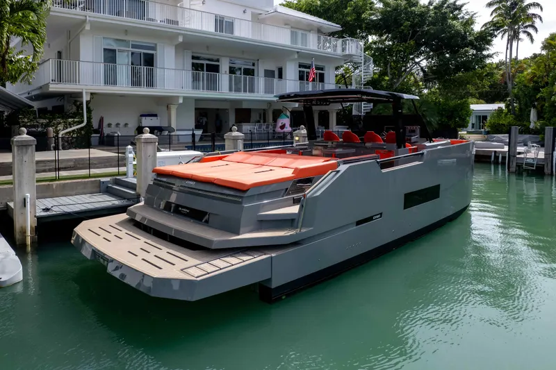 Slide: The Image of 2023 De Antonio Yachts D50 docked, featuring sleek design and vibrant orange seating. - 17