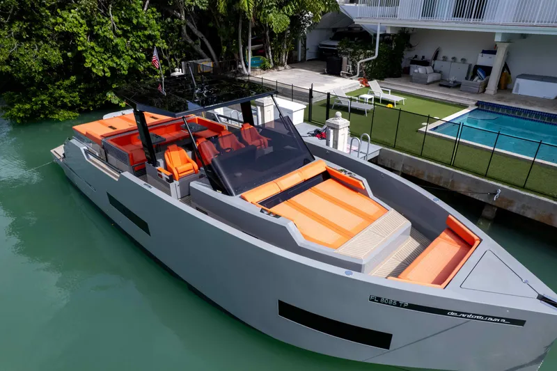 Slide: The Image of 2023 De Antonio Yachts D50 with sleek design, docked near a poolside area. - 19