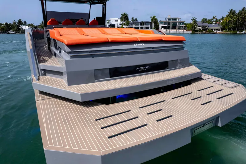 Slide: The Image of 2023 De Antonio Yachts D50 with orange seating, docked on calm water. - 2