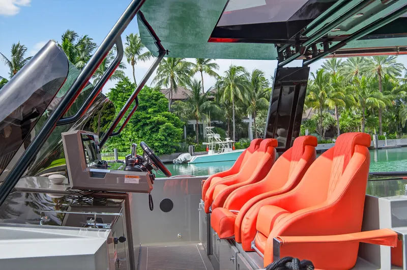 Slide: The Image of 2023 De Antonio Yachts D50 interior with vibrant orange seats and modern controls. - 21
