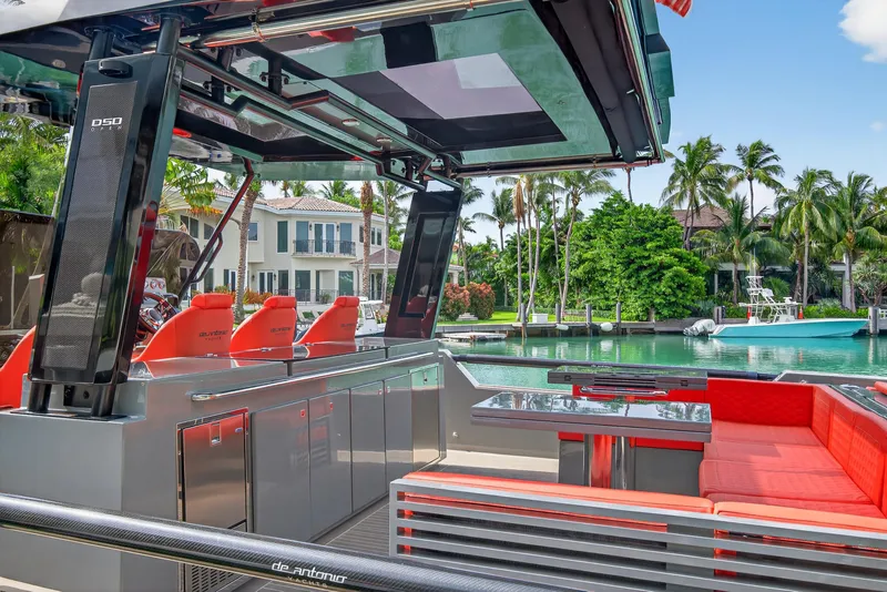 Slide: The Image of Luxurious 2023 De Antonio Yachts D50 with sleek design and vibrant red seating, docked by waterfront homes. - 22