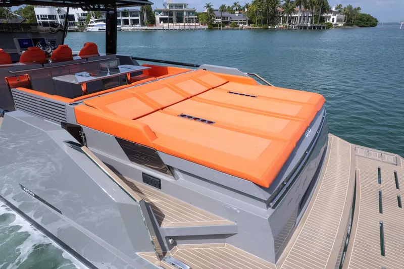 Slide: The Image of 2023 De Antonio Yachts D50 with orange sunbeds, docked by waterfront homes. - 30