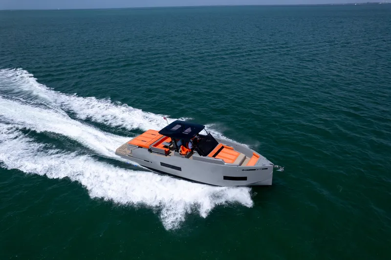 Slide: The Image of 2023 De Antonio Yachts D50 cruising on open water, featuring sleek design and vibrant orange seating. - 34