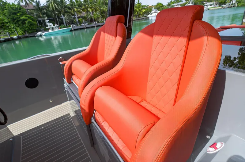 Slide: The Image of Luxurious orange seats on 2023 De Antonio Yachts D50, docked by a serene waterfront. - 41