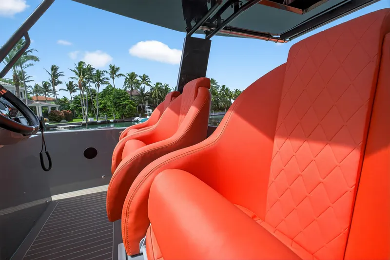 Slide: The Image of 2023 De Antonio Yachts D50 with vibrant orange seats, luxurious design, and scenic waterfront view. - 43