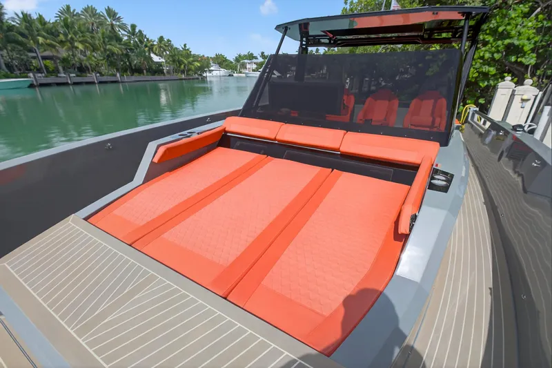 Slide: The Image of 2023 De Antonio Yachts D50 with orange seating, docked by lush greenery. - 44