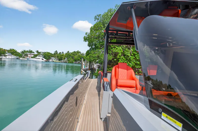 Slide: The Image of 2023 De Antonio Yachts D50 with vibrant orange seating, docked by a serene waterfront. - 45