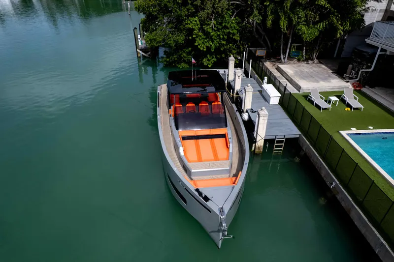 Slide: The Image of 2023 De Antonio Yachts D50 docked near a pool, showcasing sleek design and vibrant seating. - 7