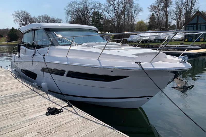 Slide: The Image of 2025 Regal 38 Grande Coupe yacht docked on a serene lake. - 2