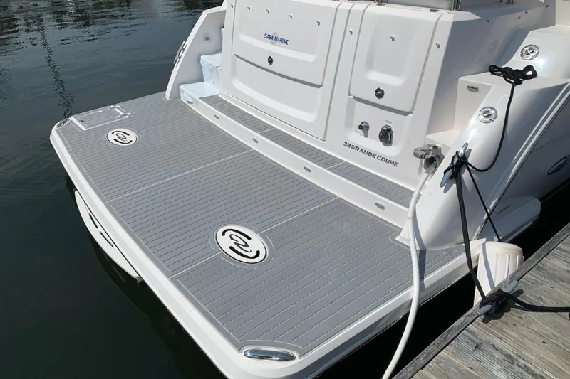 Slide: The Image of 2025 Regal 38 Grande Coupe boat stern with swim platform and docked at marina. - 6