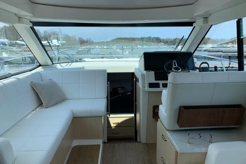 Slide: The Image of Interior of 2025 Regal 38 Grande Coupe yacht with modern seating and helm. - 7