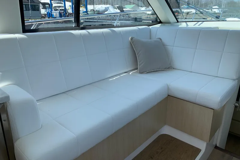 Slide: The Image of Luxurious white seating area inside 2025 Regal 38 Grande Coupe yacht. - 9