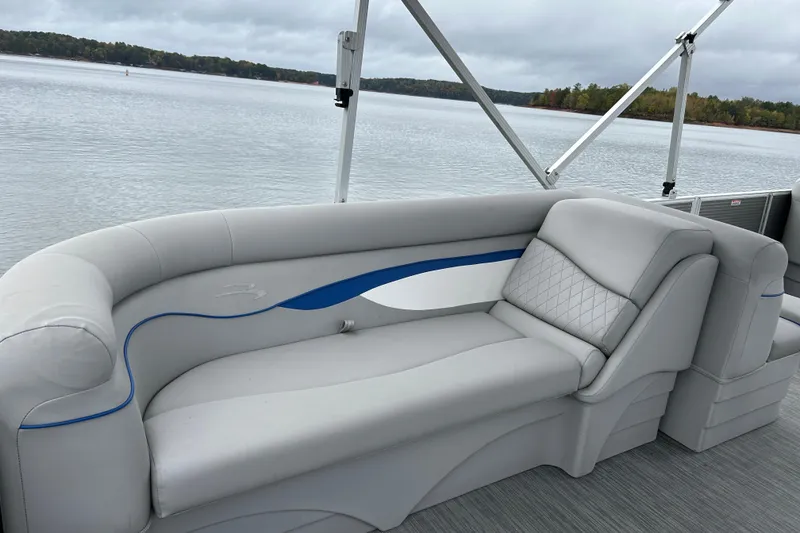 Slide: The Image of 2023 Bennington 22 SSR pontoon boat with luxurious seating on a serene lake. - 16