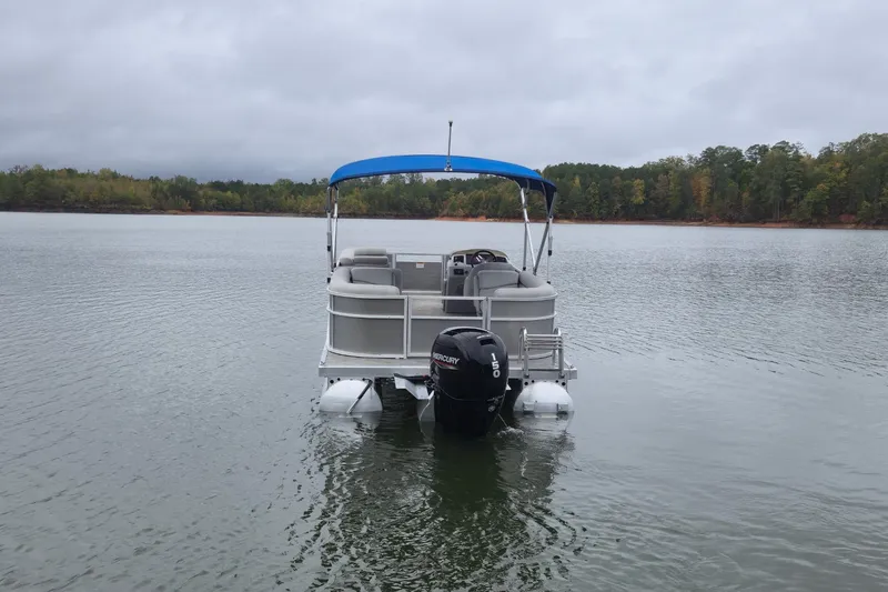 Slide: The Image of 2023 Bennington 22 SSR pontoon boat on a calm lake with overcast skies. - 7