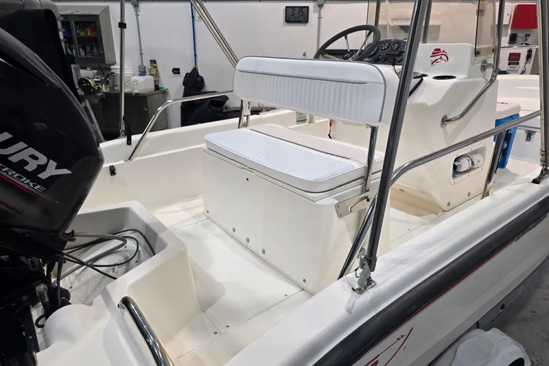 Slide: The Image of 1999 Boston Whaler Dauntless 14 boat interior with seating and Mercury engine. - 13