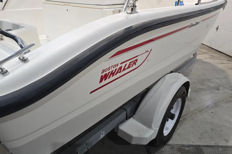 Slide: The Image of 1999 Boston Whaler Dauntless 14 boat on trailer in indoor setting. - 14