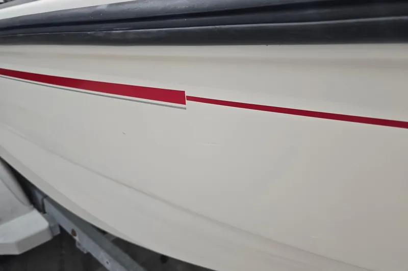 Slide: The Image of 1999 Boston Whaler Dauntless 14 boat hull with red stripe detail. - 18