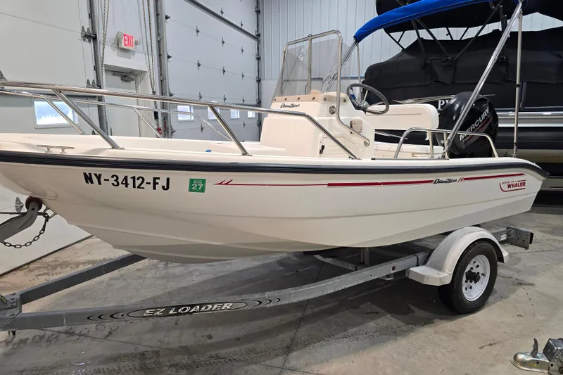 Slide: The Image of 1999 Boston Whaler Dauntless 14 boat on trailer in indoor storage. - 22