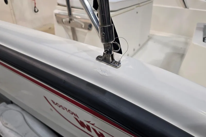 Slide: The Image of 1999 Boston Whaler Dauntless 14 boat detail showing railing and logo. - 25
