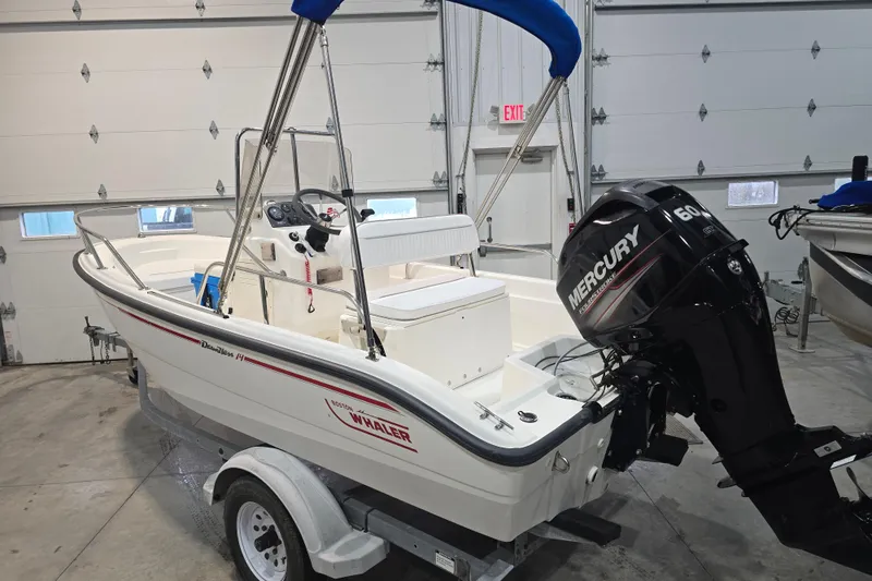 Slide: The Image of 1999 Boston Whaler Dauntless 14 boat with Mercury 60 HP engine in a garage. - 27
