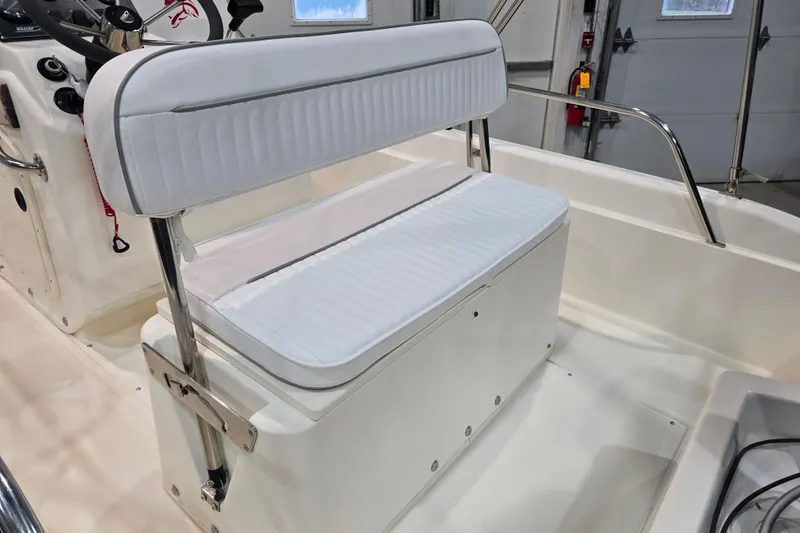 Slide: The Image of 1999 Boston Whaler Dauntless 14 boat interior with white cushioned seating. - 28