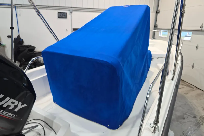 Slide: The Image of 1999 Boston Whaler Dauntless 14 boat with blue cover in a garage setting. - 41