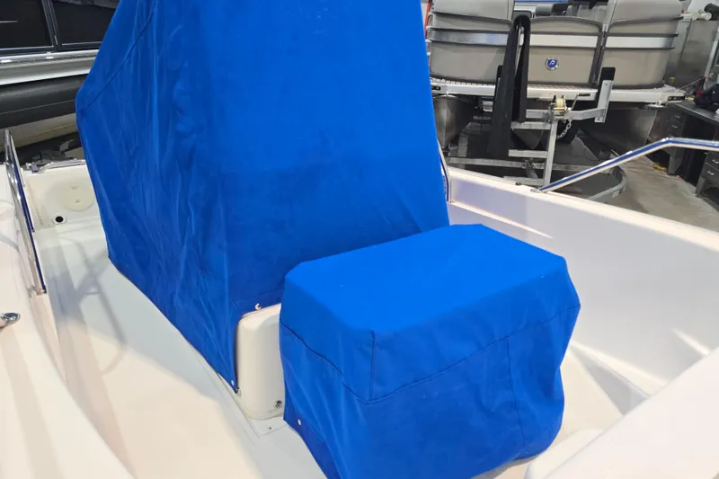 Slide: The Image of 1999 Boston Whaler Dauntless 14 boat with blue protective covers in a showroom. - 43