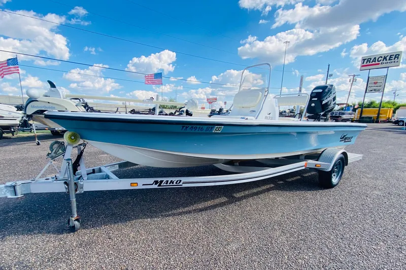 The Image of 2013 Mako 18 LTS boat on trailer, displayed outdoors under blue sky. - 1