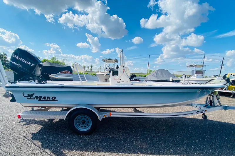 Slide: The Image of 2013 Mako 18 LTS boat on trailer under a bright blue sky. - 2