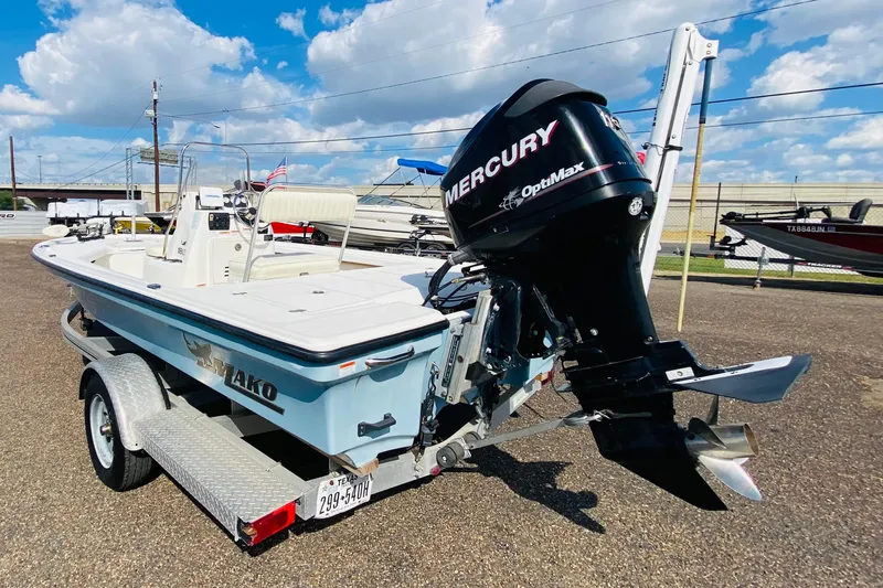 Slide: The Image of 2013 Mako 18 LTS boat with Mercury OptiMax engine on trailer, under blue sky. - 5