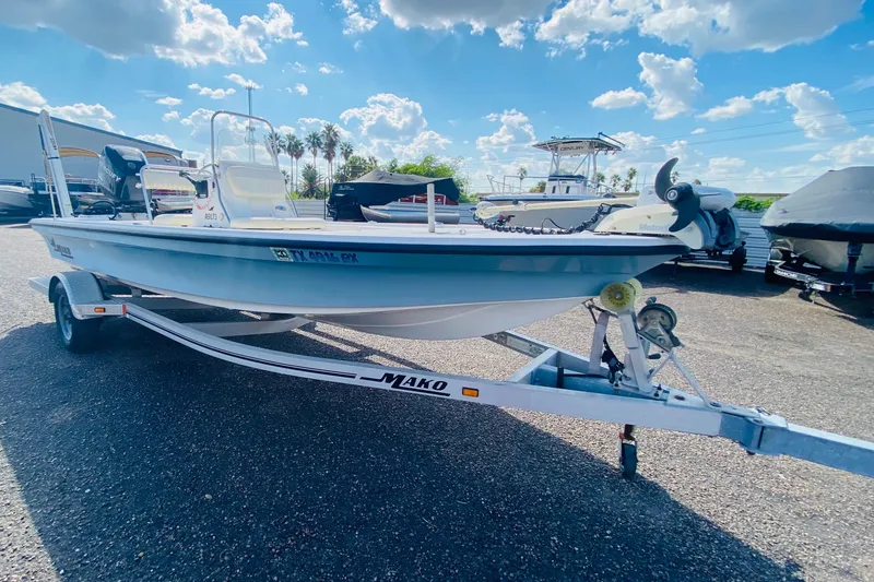 Slide: The Image of 2013 Mako 18 LTS boat on trailer under a bright blue sky. - 9
