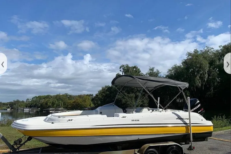 The Image of 2016 Hurricane SunDeck Sport 232 OB boat on trailer, under blue sky. - 0