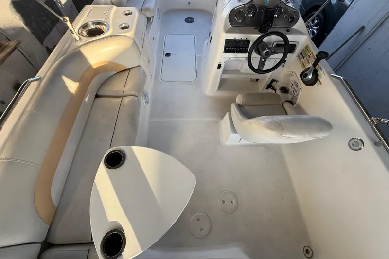 Slide: The Image of 2016 Hurricane SunDeck Sport 232 OB boat interior with seating and steering console. - 16