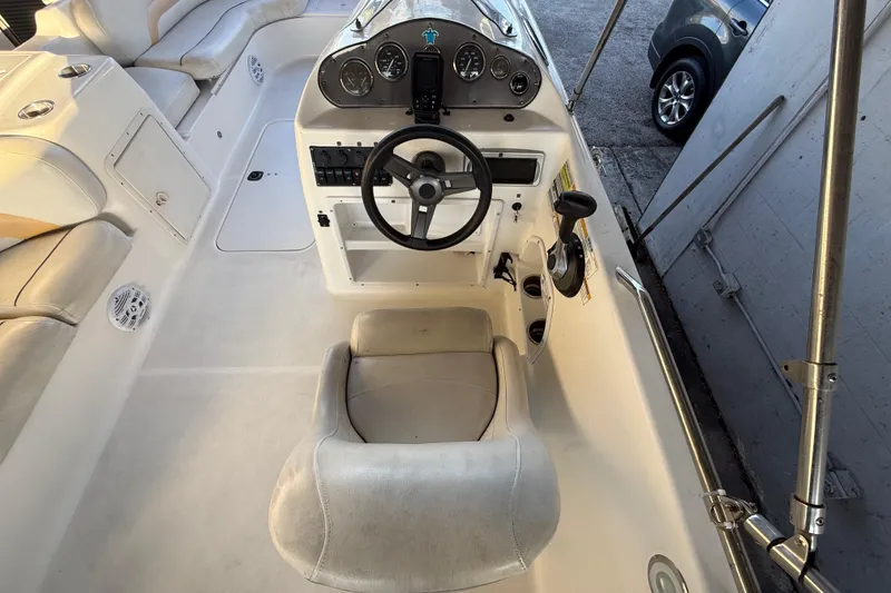 Slide: The Image of 2016 Hurricane SunDeck Sport 232 OB boat interior with steering wheel and seating. - 19