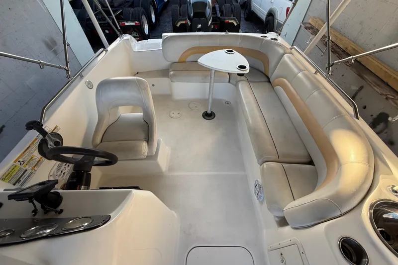 Slide: The Image of 2016 Hurricane SunDeck Sport 232 OB interior with seating and steering wheel. - 49
