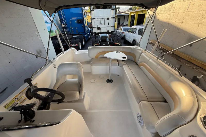Slide: The Image of 2016 Hurricane SunDeck Sport 232 OB interior with seating and steering wheel. - 50