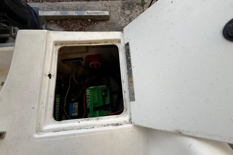 Slide: The Image of 2016 Hurricane SunDeck Sport 232 OB battery compartment with visible wiring and components. - 53