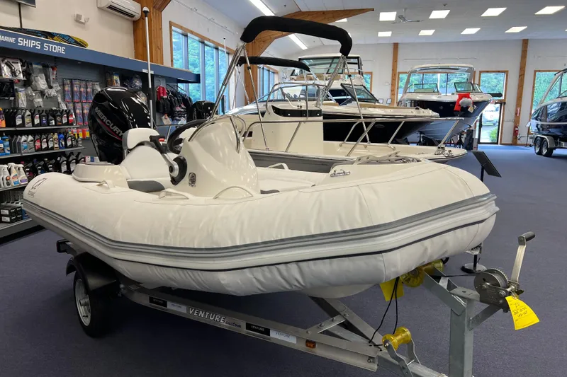Slide: The Image of 2023 Zodiac Yachtline 360 inflatable boat displayed in a showroom on a trailer. - 1