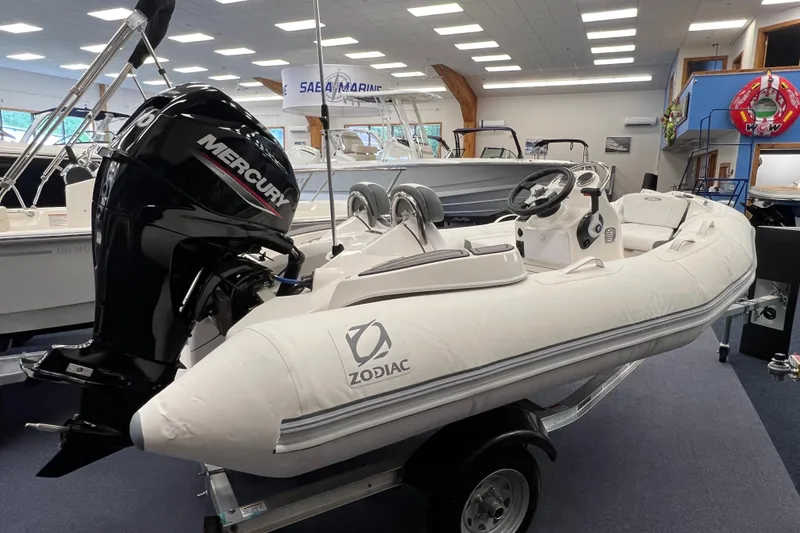 Slide: The Image of 2023 Zodiac Yachtline 360 inflatable boat with Mercury engine displayed indoors. - 2